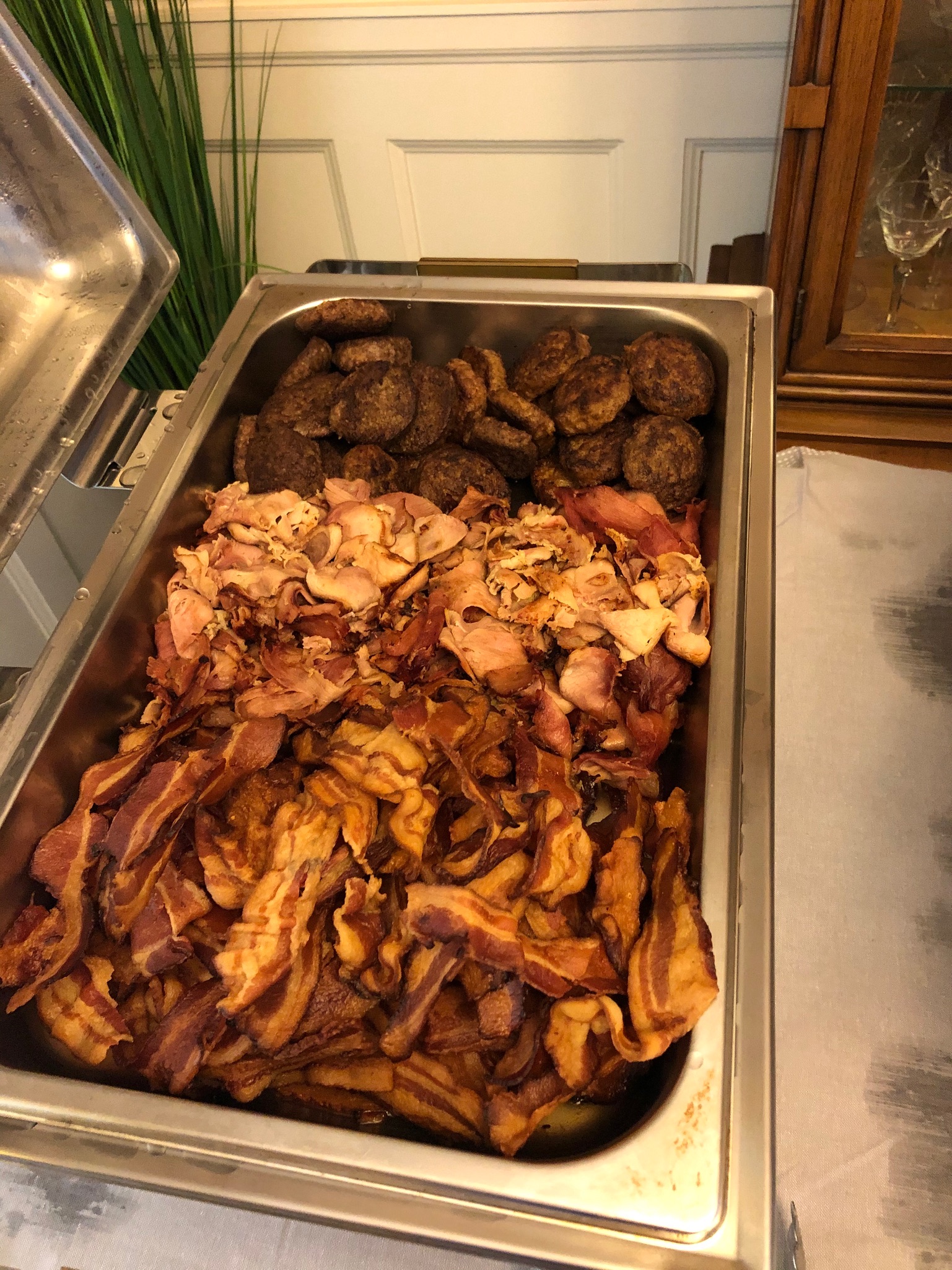 Breakfast spread with crisp bacon, griddle sausage patties, and frizzled ham