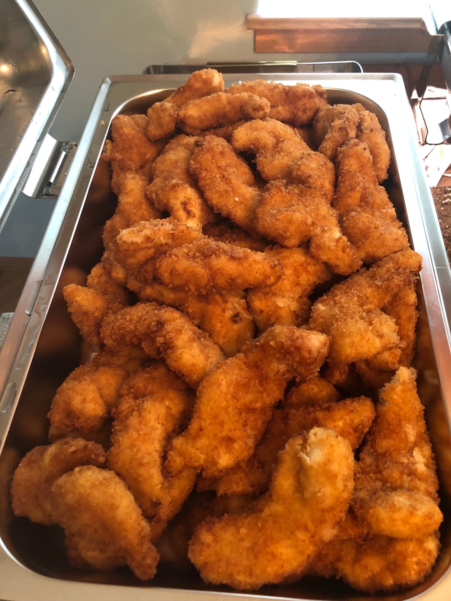 Buttermilk and panko breaded chicken tenderloins in a chafing dish